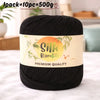 Black silk bamboo blend yarn skein with a label indicating premium quality