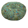A round throw cushion with a blue and teal bohemian pattern on a light beige background.