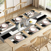 A modern geometric placemat set for dining featuring black, white, and gray patterns with small white floral accents.