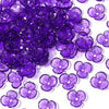 A pile of purple resin flower bead caps for jewelry making.