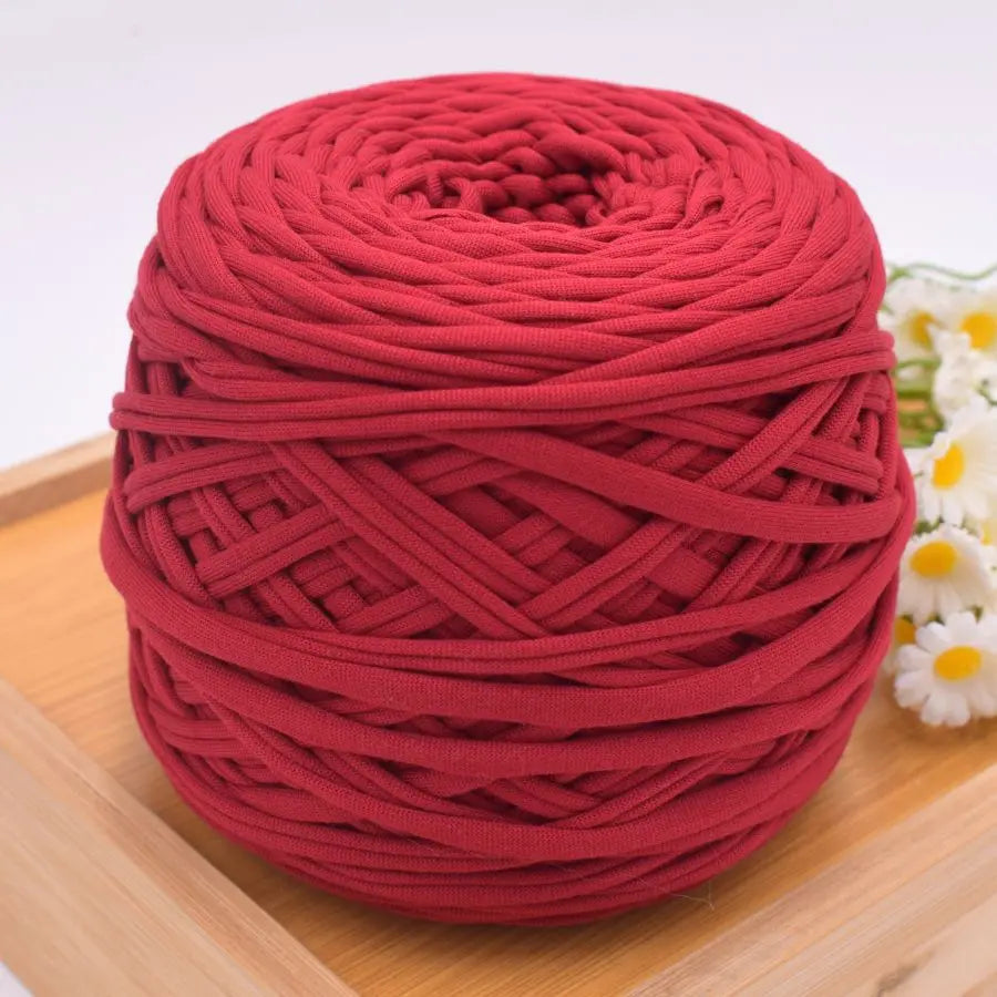 A ball of deep red craft yarn made of 100% polyester for knitting and DIY projects.