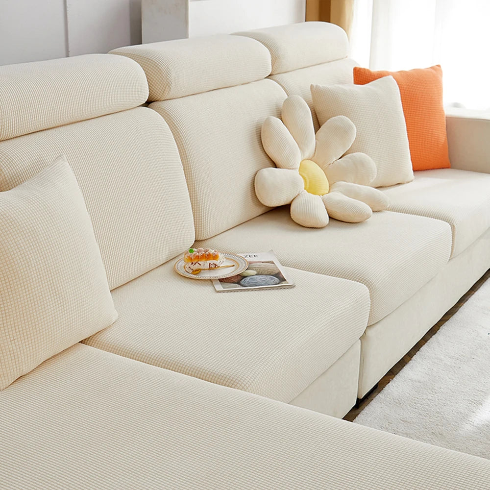 A cream-colored sofa seat cushion cover with a textured fabric and decorative floral pillows.