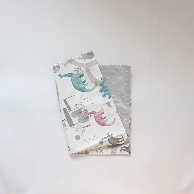 A stack of soft cotton baby pillow covers featuring watercolor illustrations of sea creatures like dolphins and fish.