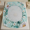 A white floral print fitted mattress protector sheet is displayed on a white bed frame.
