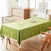 A lime green table is set with white floral arrangements and textured cotton tassel table runners.