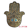 Gold and black sequin iron-on patch shaped like a hand with a blue eye design
