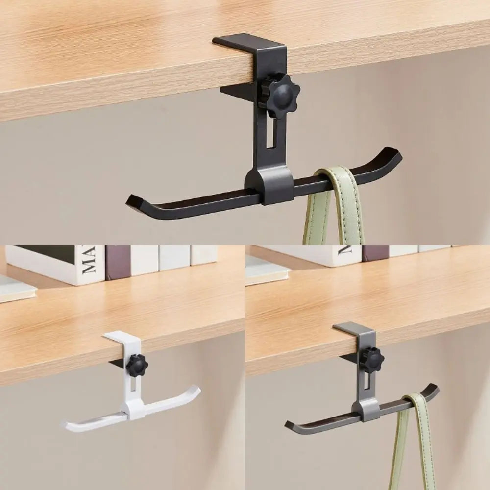 A black adjustable aluminum alloy desk hook with dual clips and a light green strap is shown mounted on a wooden shelf.