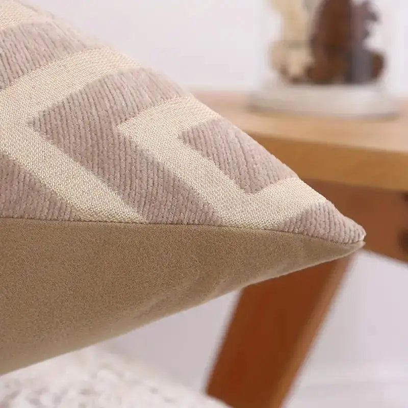 A close-up of a beige chenille jacquard throw pillowcase with a diamond pattern on a wooden surface.