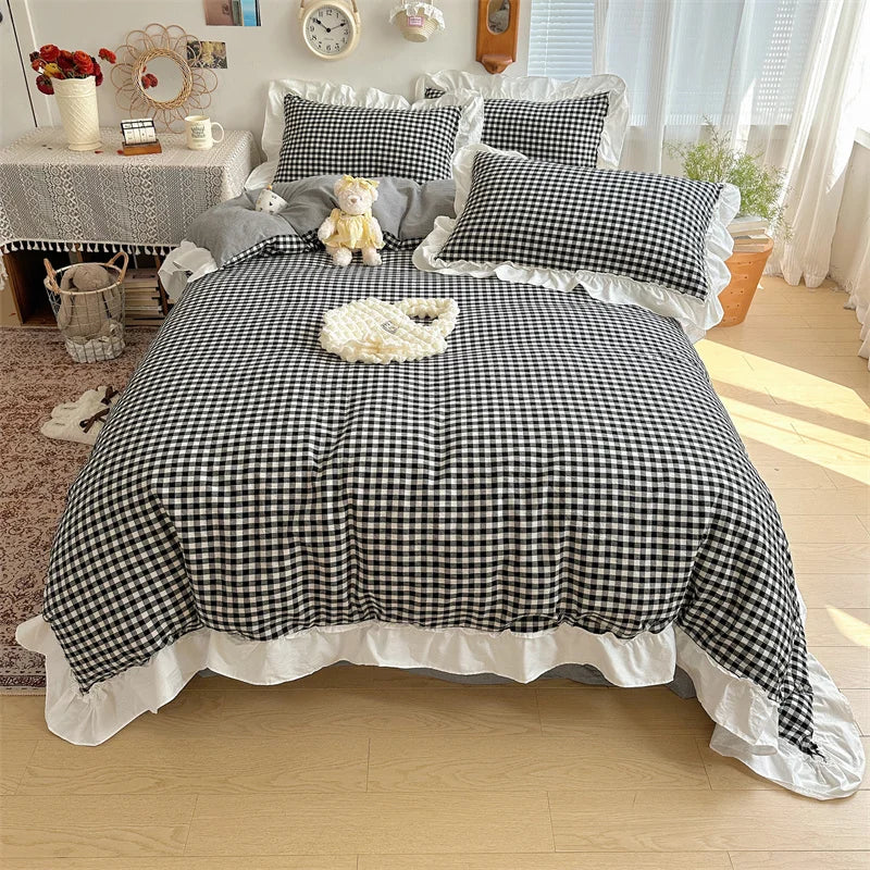 A plaid duvet cover set featuring black and white checks with lace embroidery, displayed on a bed.
