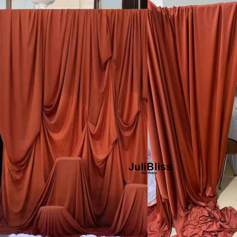 A close-up of draped orange fabric used for decor, showing soft folds and texture.