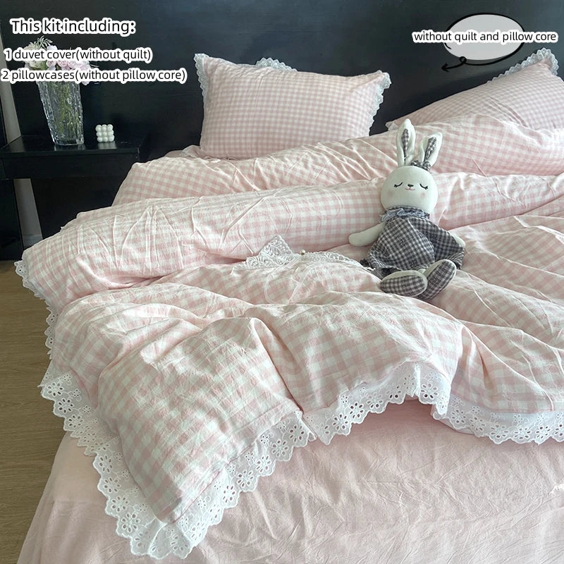 A pink plaid duvet cover and pillowcase set with a bunny plush toy on a bed.