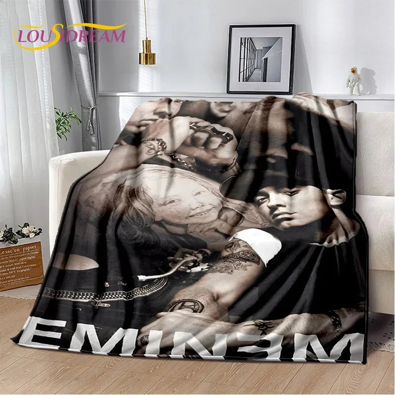 A dark graphic throw blanket featuring a vintage-inspired portrait of a woman and a man.