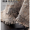 Close-up of a textured, knitted sofa cover in beige and black tones.