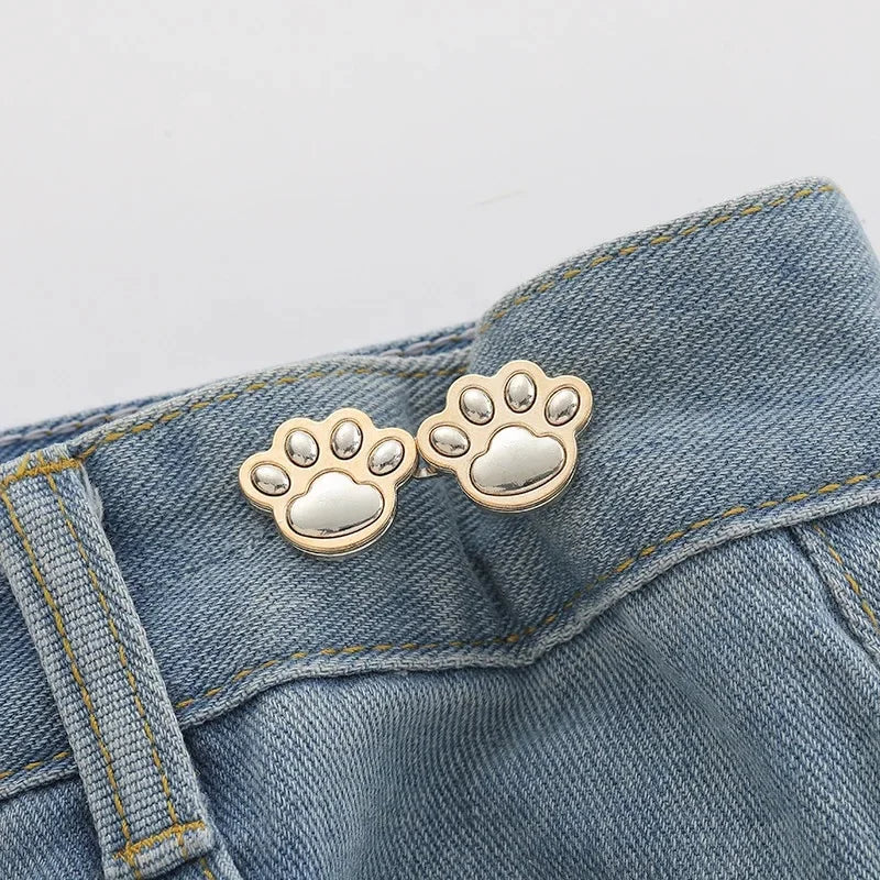 Silver paw print button clips attached to a denim fabric