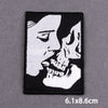 Black and white embroidered patch featuring a profile of a human face and a skull.