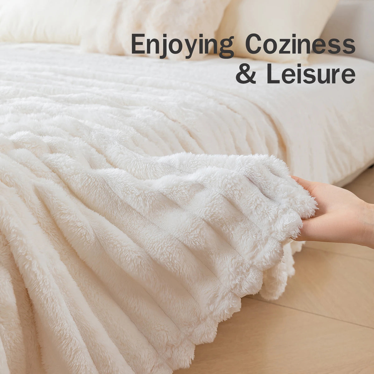 A hand is touching a fluffy white blanket draped over a bed, enjoying coziness and leisure.