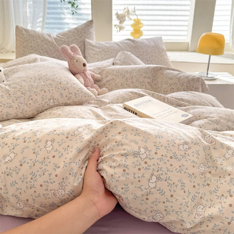 A beige duvet set featuring a cute dog print pattern, displayed on a bed with white blinds and soft lighting.