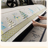 A close-up of a sofa mat cover featuring a Christmas deer pattern in yellow and white embroidery.