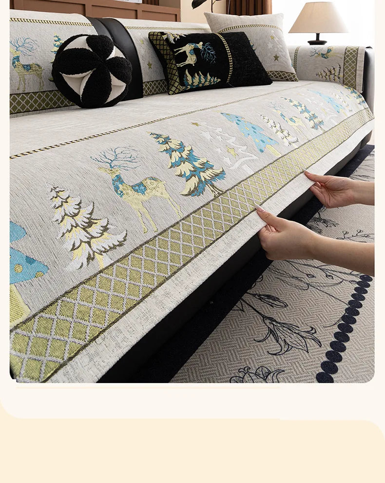 A close-up of a sofa mat cover featuring a Christmas deer pattern in yellow and white embroidery.