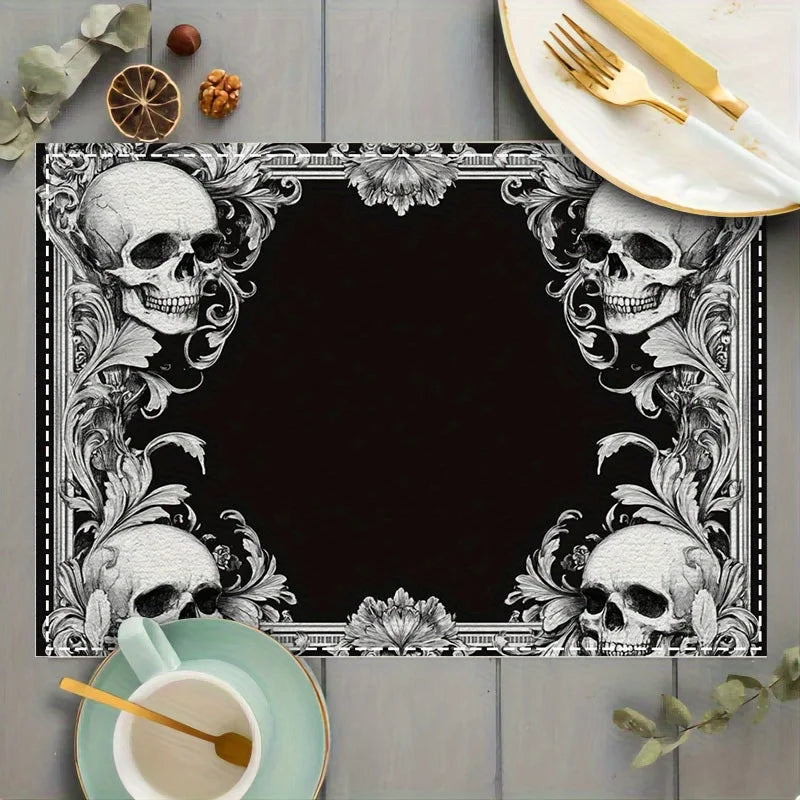 A black square placemat featuring a white gothic floral design with skulls and leaves, set on a wooden table.