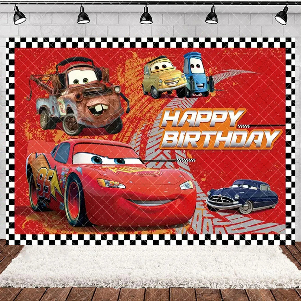 A vibrant cartoon racing birthday party backdrop featuring cars like Lightning McQueen and others against a red background.