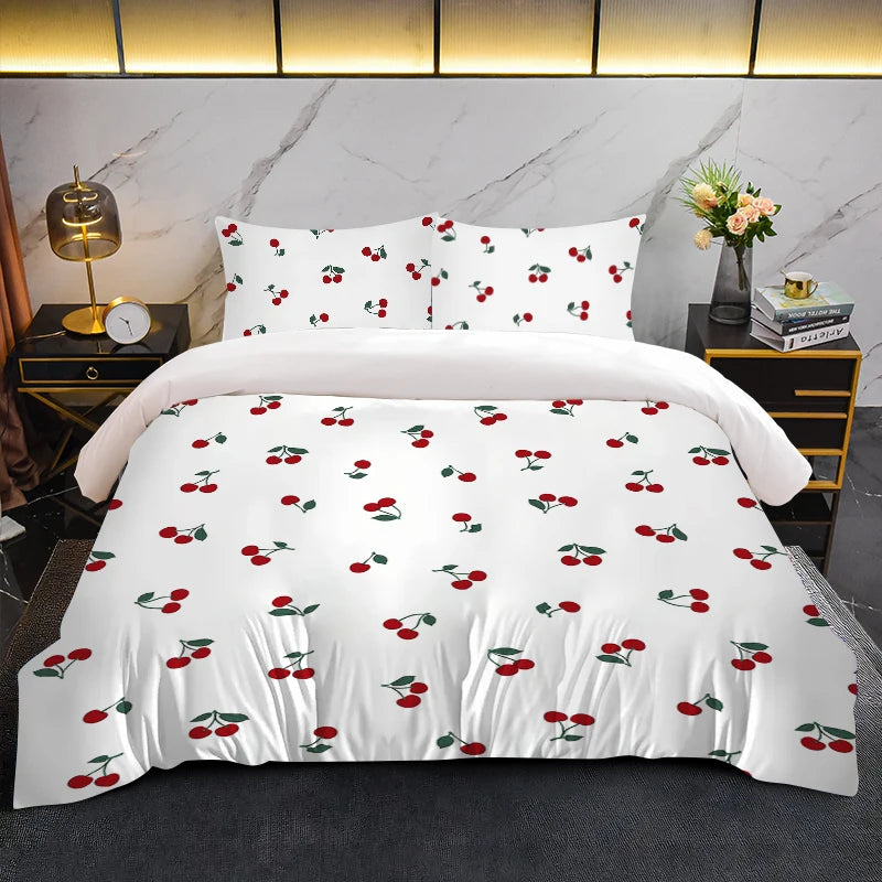 White duvet cover set with a red fruit print featuring cherries on a bed.