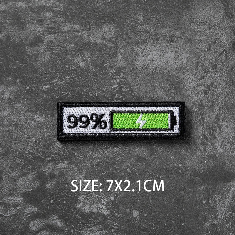 A black hook and loop badge with 99% visible on the left and a green lightning bolt symbol on the right, measuring 7x2.1cm.