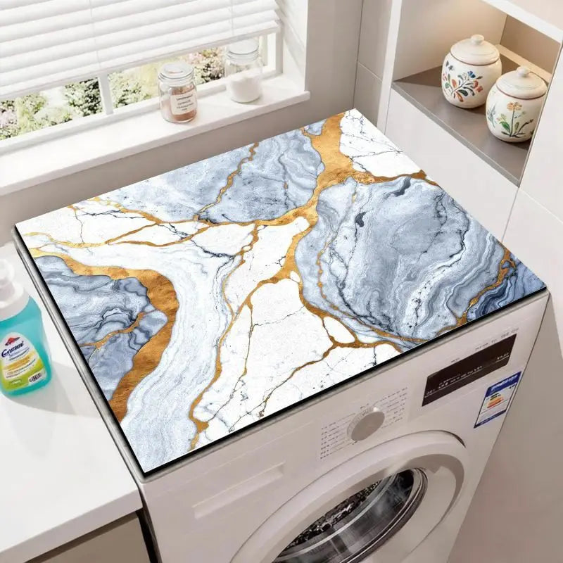 A white wood grain fridge cover mat with marbled blue and gold patterns is placed inside a white washing machine.