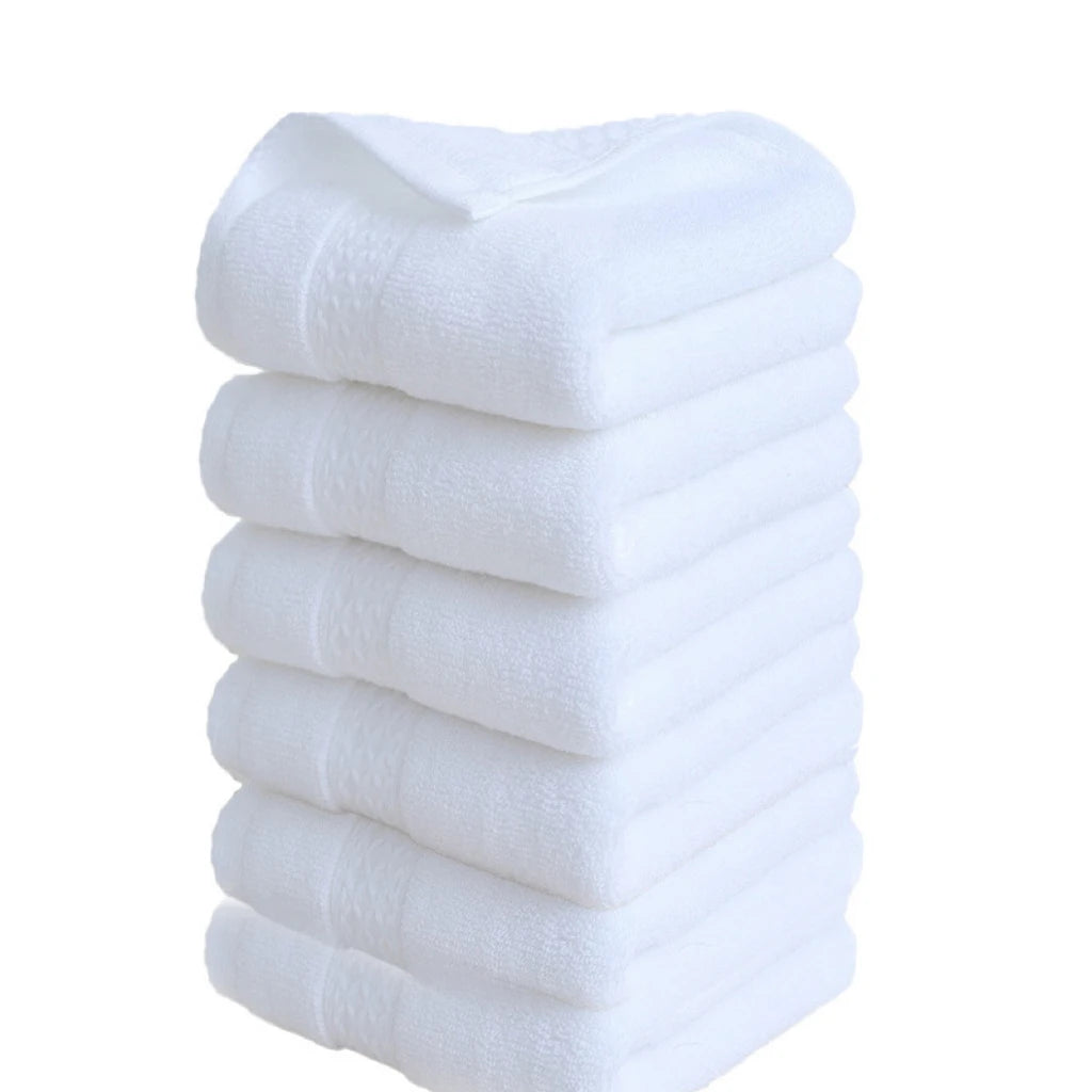 A stack of six white premium pure cotton face towels.