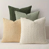 A collection of decorative pillow covers in shades of green and cream, featuring a textured, quilted pattern.