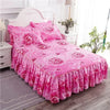 Pink floral printed bed skirt with pink bedding and white furniture