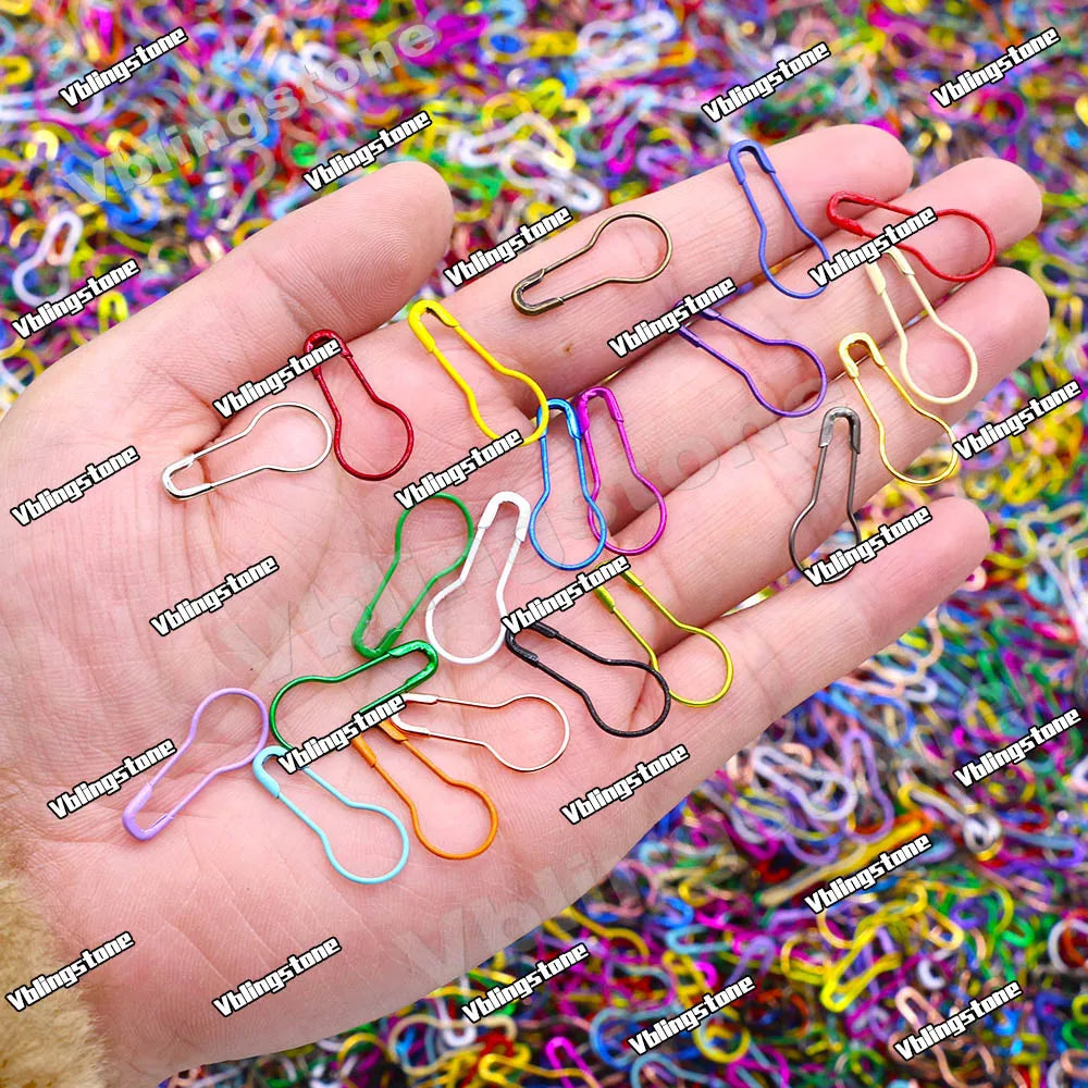 A hand holds a collection of colorful gourd-shaped locking safety pins for knitting and sewing.