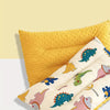 A yellow and cream reversible fiber pillow featuring cartoon animals for infants.