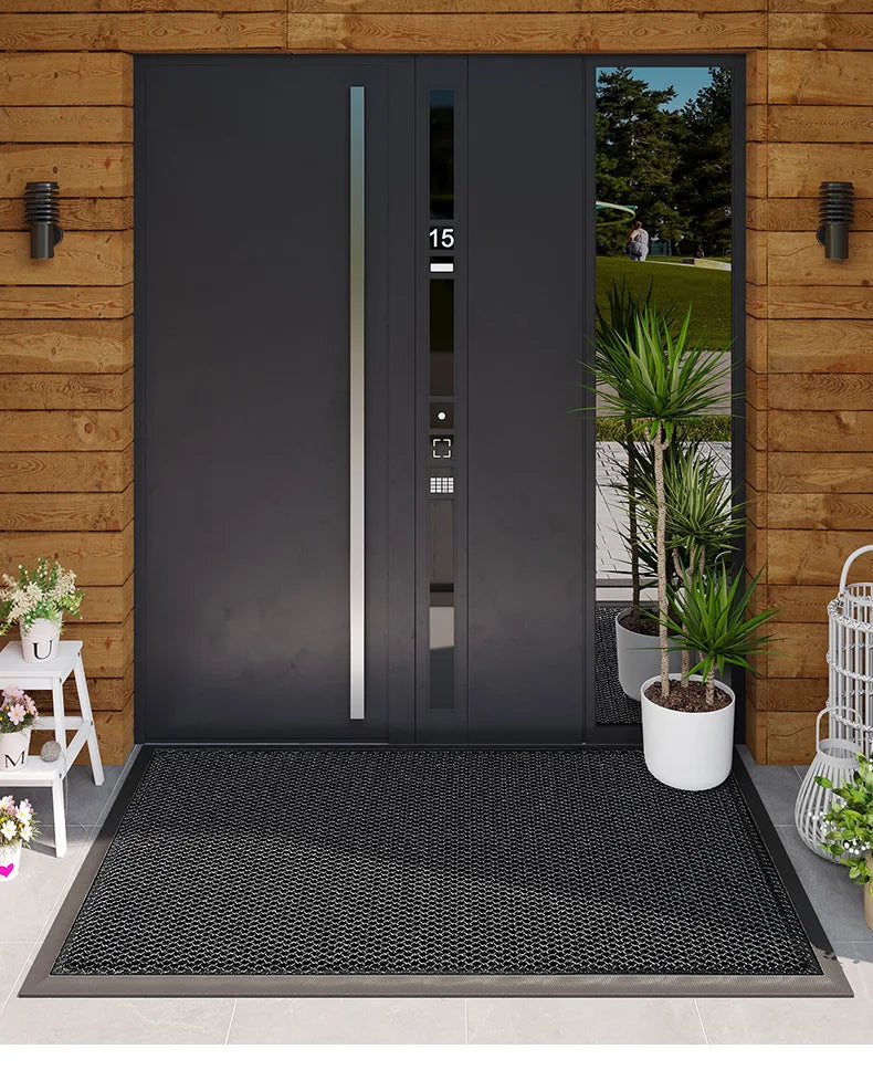 A dark gray modern door with vertical glass panels and a black non-slip rubber doormat in front of it.