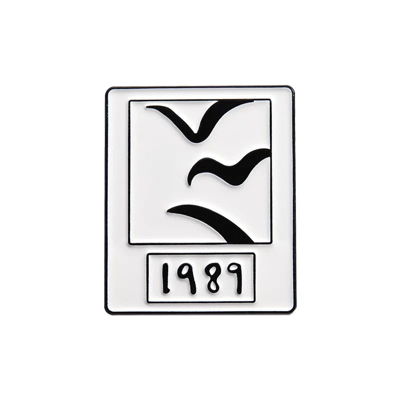 A vintage enamel lapel pin featuring a silhouette of a bird and the year 1989.