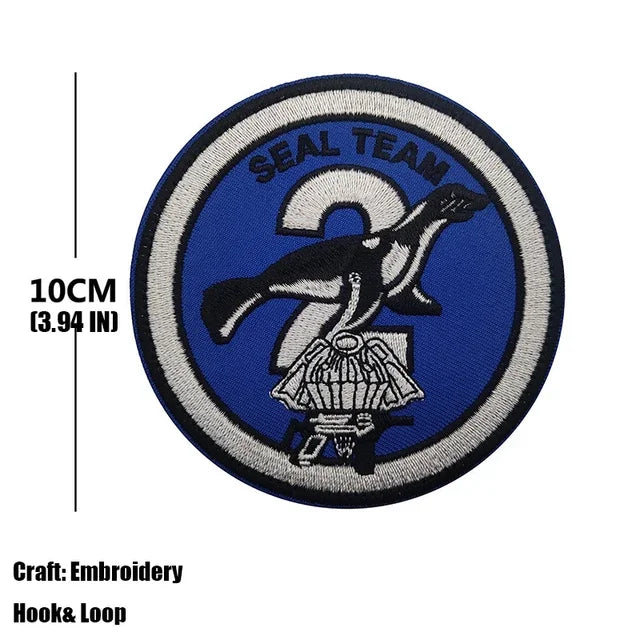 A dark blue embroidered patch featuring a silhouette of a seal and the text SEAL TEAM.