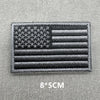 A black and gray USA flag patch with horizontal stripes and stars, featuring hook and loop backing.