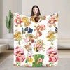 A plush throw blanket featuring colorful strawberry shortcake characters and fruit designs.