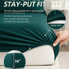 Close-up of a dark green fitted sheet with elastic hems and deep pockets, demonstrating a secure grip.