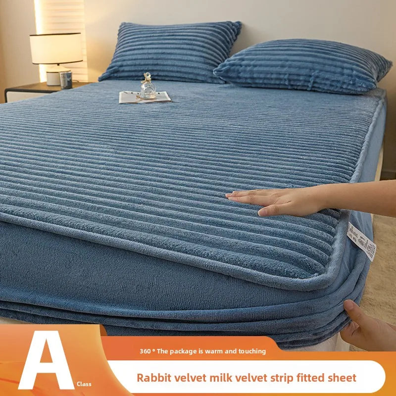 A blue rabbit velvet milk velvet strip fitted sheet is shown folded on a bed.