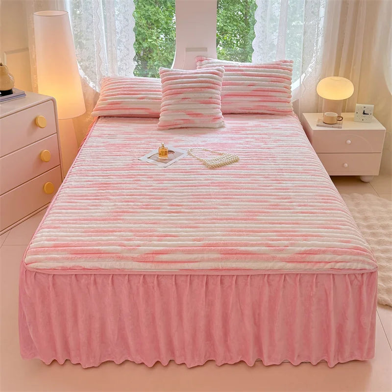 A pink linen bed skirt set featuring striped pink and white bedding and pillows.