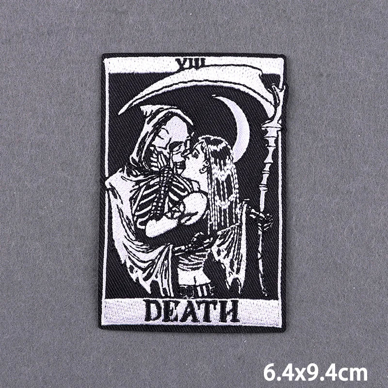 A black and white embroidery patch featuring a crescent moon and two figures embracing, with the word DEATH below.