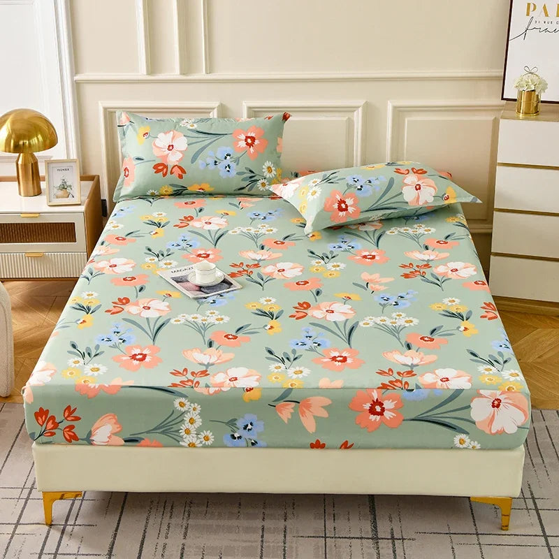 A floral fitted sheet set with light green fabric and pink, orange, and blue flowers displayed on a bed.