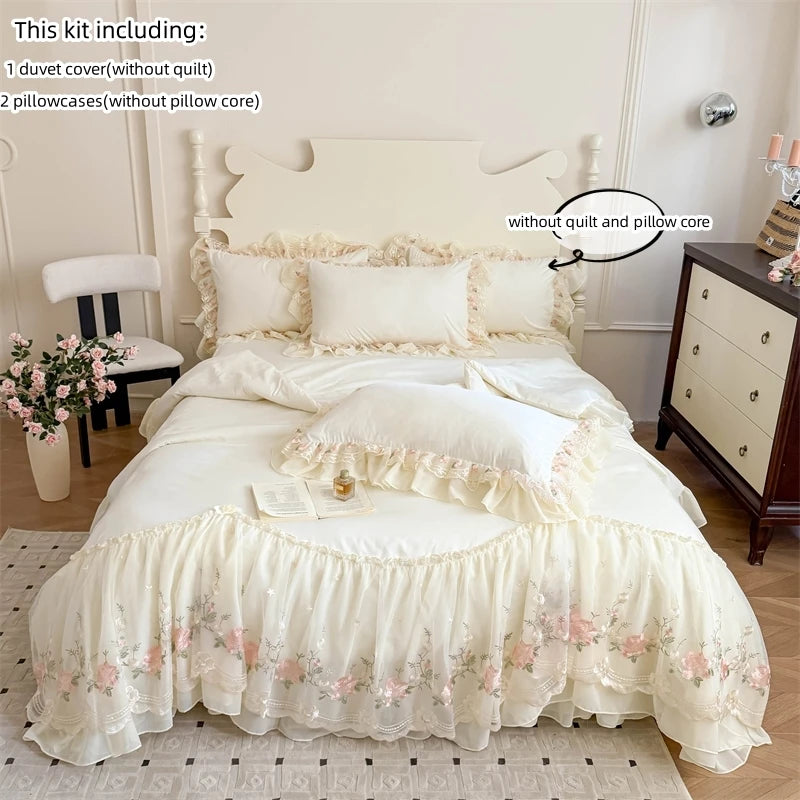 A white Korean style lace embroidered duvet set displayed on a bed with a light wood headboard and bedside table.