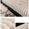 A beige, ribbed plush sofa seat cushion is shown in a living room setting with fluffy accents.