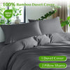 A gray bamboo duvet cover set displayed on a bed with green plants in the background.