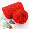 A ball of bright red chunky velvet knitting yarn used for home decor.