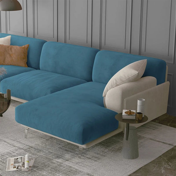 A teal velvet sofa seat cover featuring light beige cushions and a modern gray wall background.