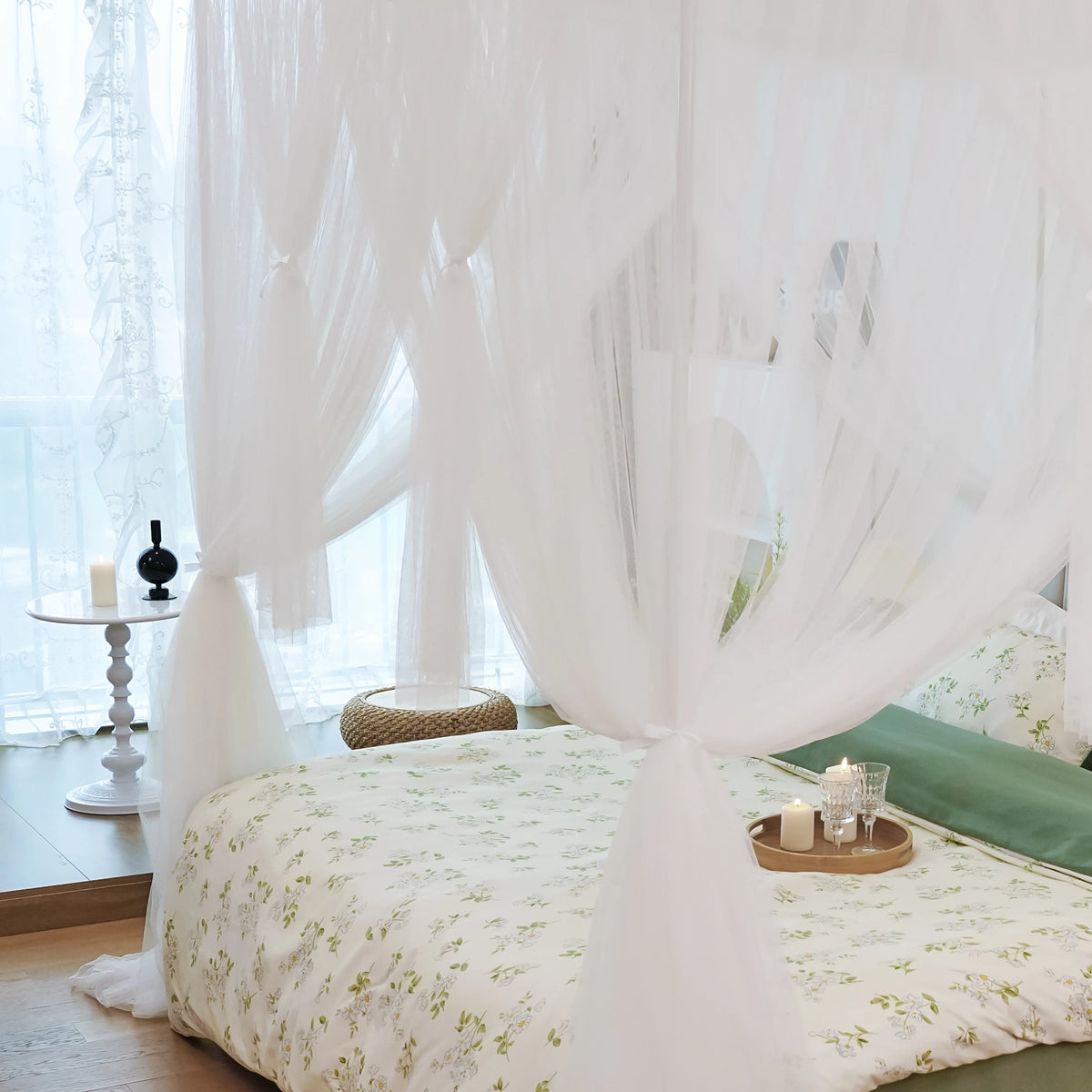 Elegant mosquito net bed canopy with sheer white fabric draped over a bed.
