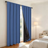 Royal blue and black blackout curtains with thermal liner hanging in a bright room.